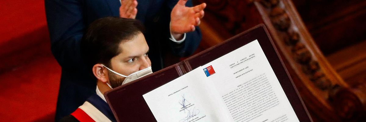 Chile's President Gabriel Boric holds the country's draft Constitution