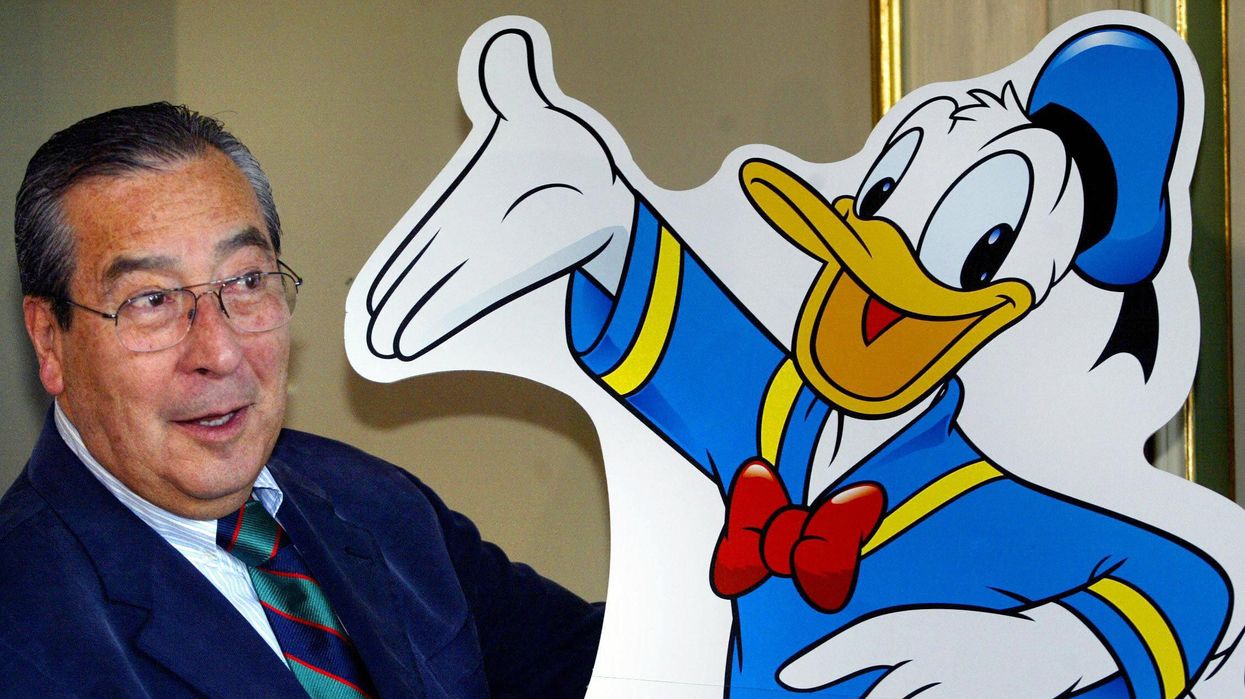 Chilean comic-strip artist Victor Arrigada Rios (Vicar) stands beside a Donald Duck