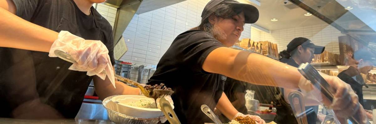 Chipotle workers prepare customer orders