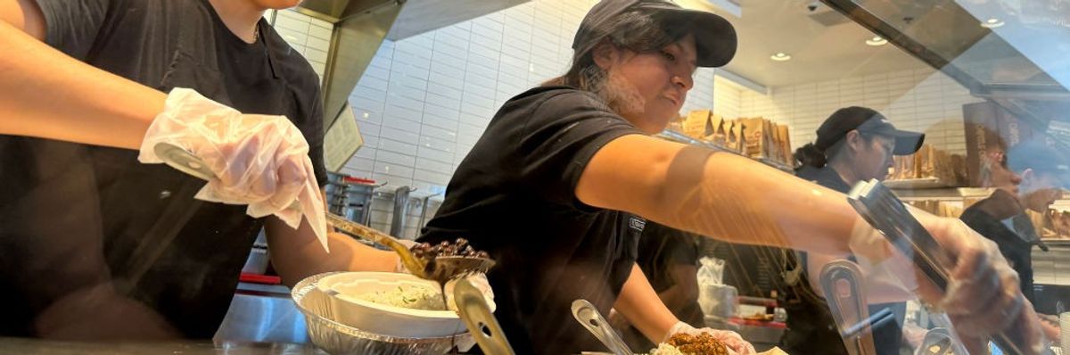 Chipotle workers prepare customer orders