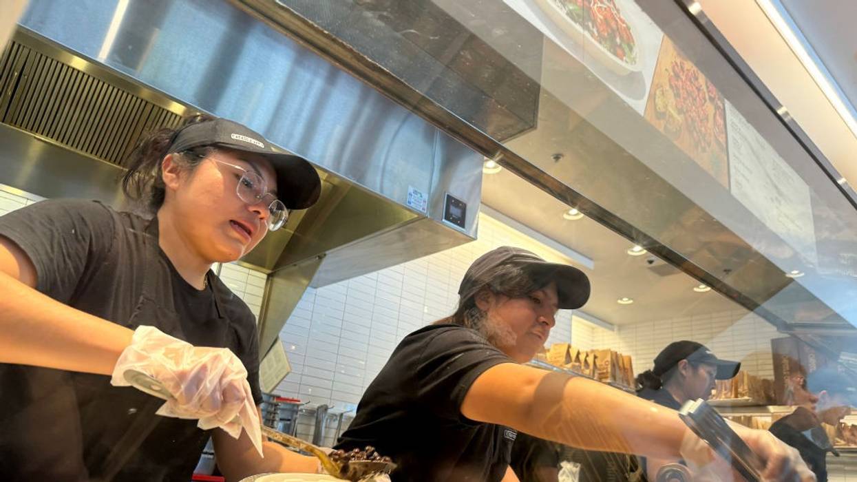 Chipotle workers prepare customer orders