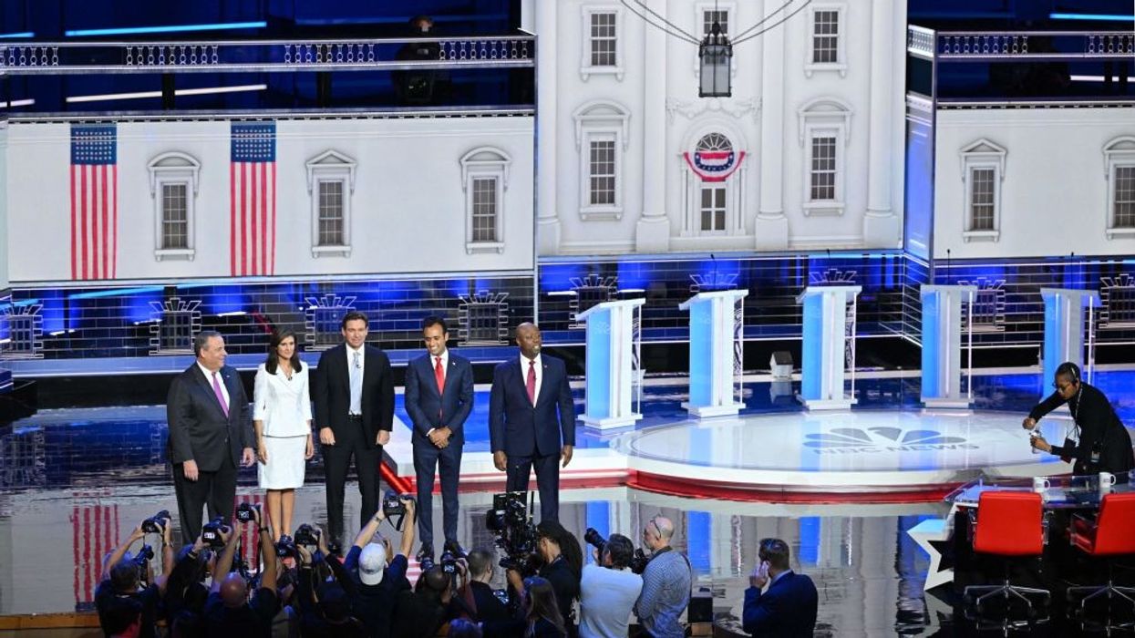 Chris Christie, Nikki Haley, Ron DeSantis, Vivek Ramaswamy, and Tim Scott stand on a debate stage in front of podiums.
