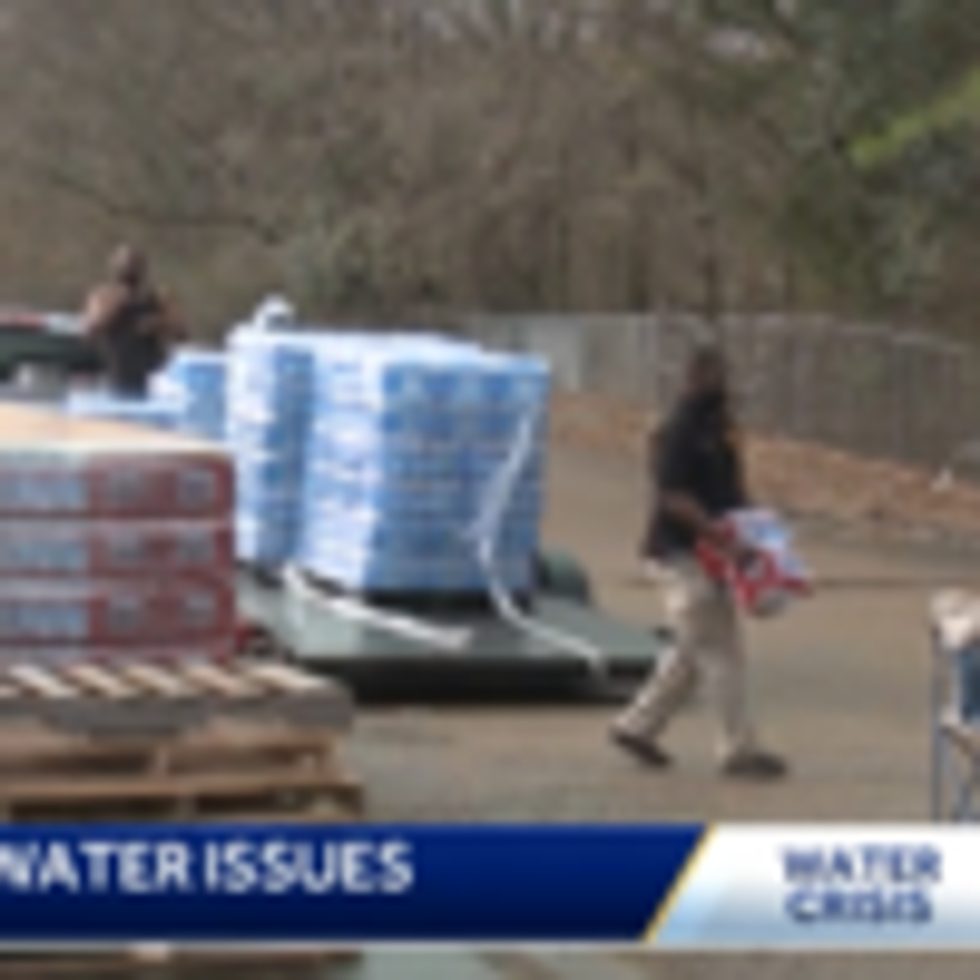 City Council President Aaron Banks carries bottled water at a local distribution center in Jackson, Mississippi. (Photo: Screengrab from ABC 16 WAPT News)