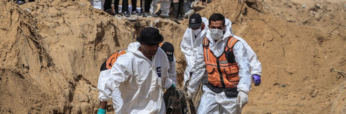 Civil Defense Authority teams remove bodies of Palestinians