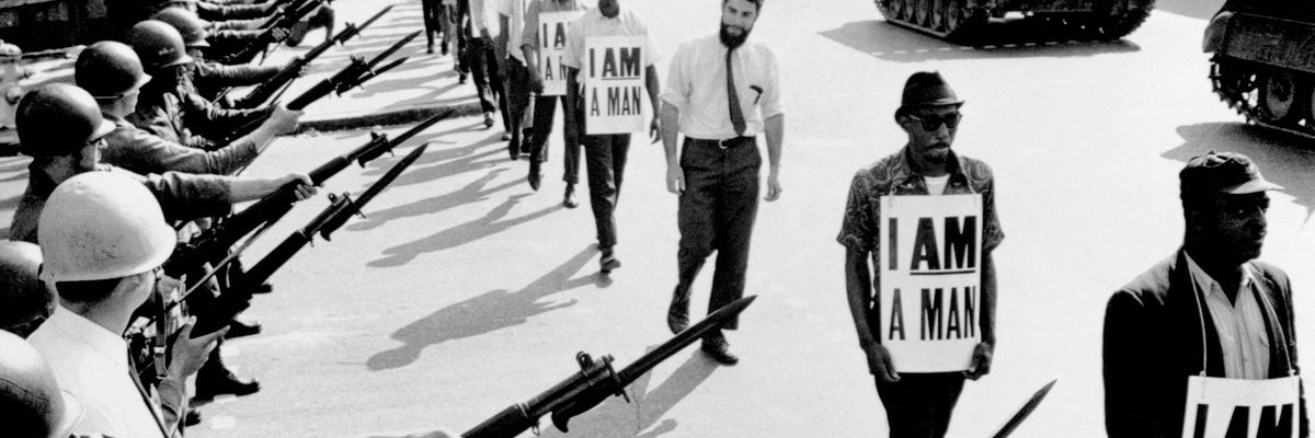 Civil rights activists and sanitation workers in Memphis, Tennessee declaring "I Am A Man" are blocked by National Guardsmen with bayonets, backed by tanks