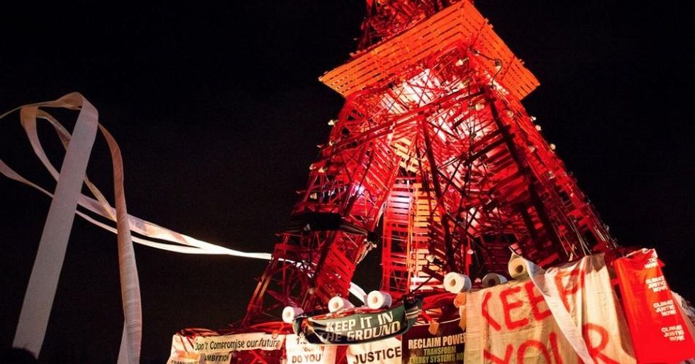 Civil Society groups attached signs to a mock Eiffel tower following Wednesday's mass sit-in. (Photo: Emma Cassidy/Survival Media Agency)