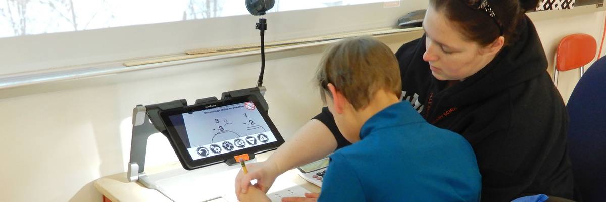 Classroom Aide Assisting Special Needs Student Using Electronic Magnifier, Wellsville, New York