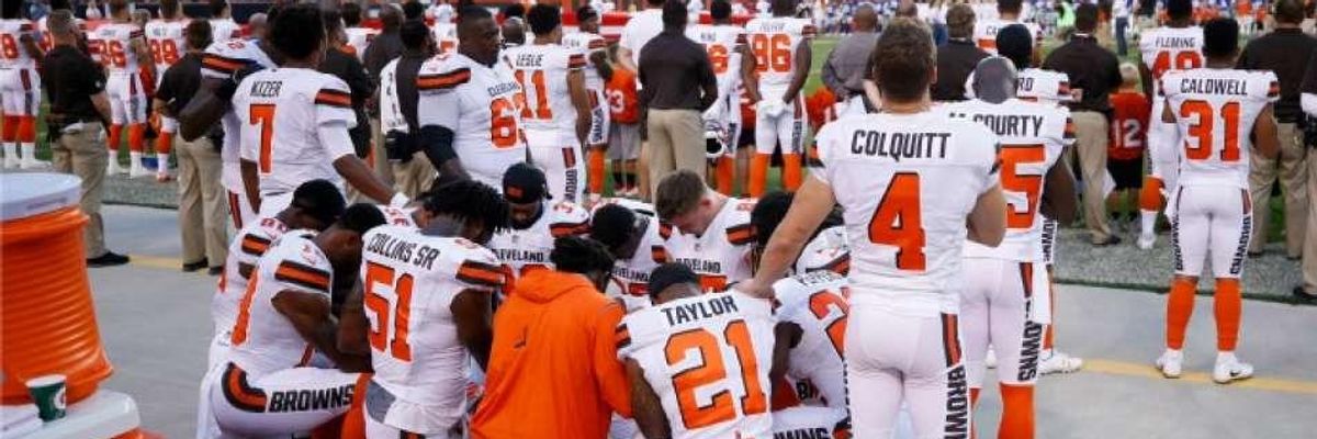 Cleveland Browns players kneel, supported by other teammates who remained standing, during the national anthem ahead of a pre-season game against the New York Giants
