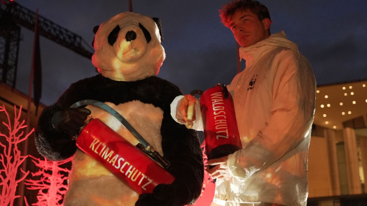 Climate activists hold fire extinguishers.