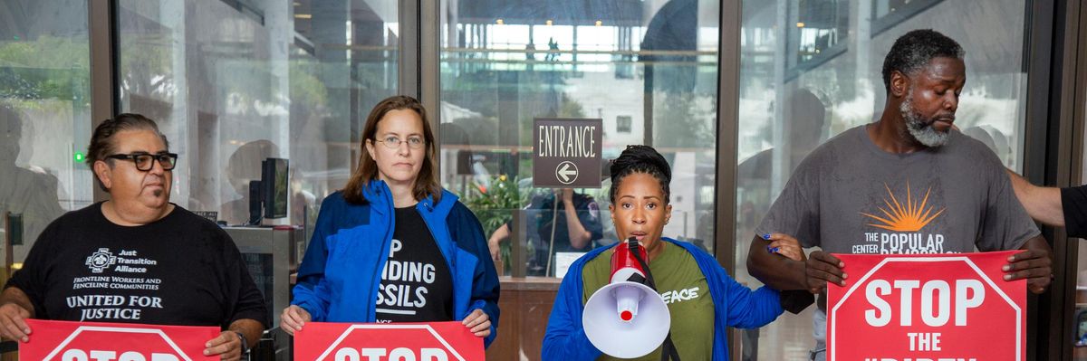 Climate leaders risking arrest hold signs saying "Stop the #DirtyDeal"