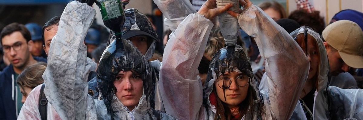 Climate protesters pour oil over them