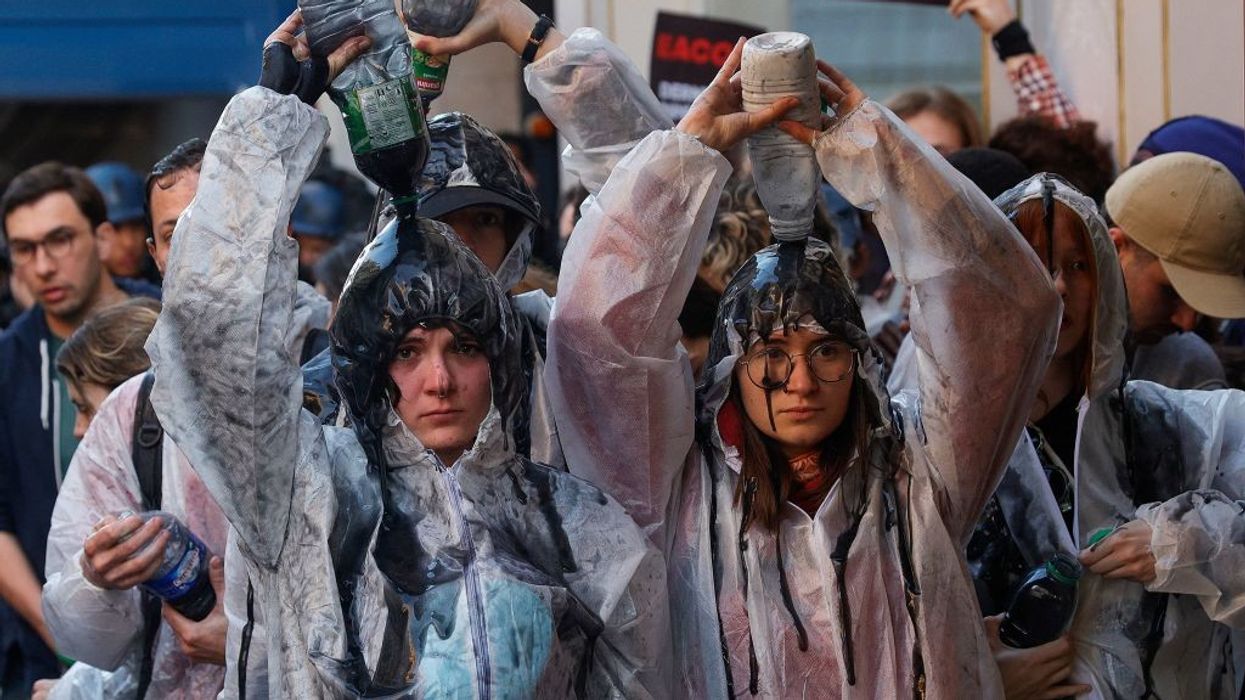 Climate protesters pour oil over them