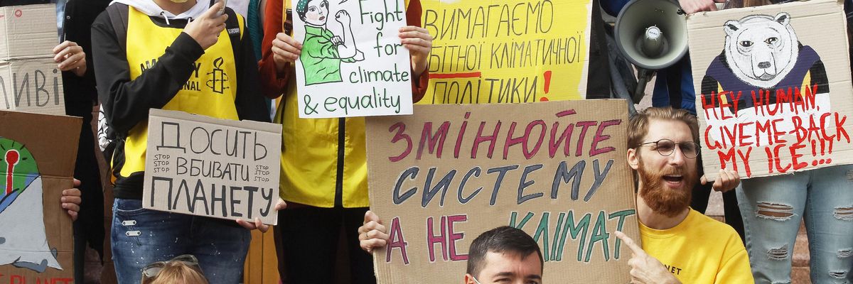 Climate protesters with the Fridays for Future movement hold placards during a demonstration outside City Hall in Kiev, Ukraine on Sept. 25, 2020.