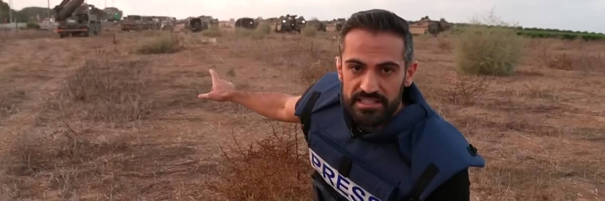 CNN's Jeremy Diamond points to IDF tanks and hardware in a field