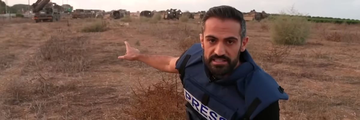 CNN's Jeremy Diamond points to IDF tanks and hardware in a field