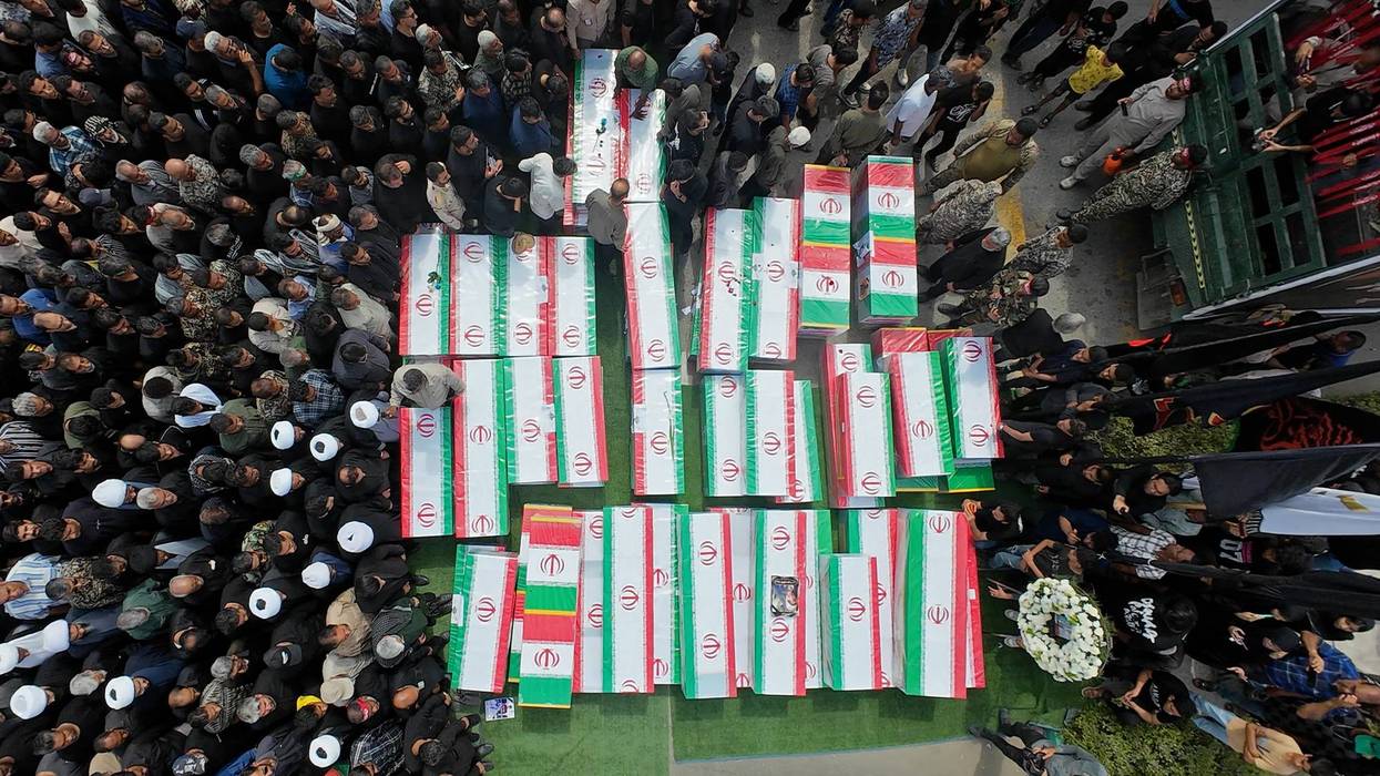 Coffins of victims of the US strike on a girls' school in Minab, Iran are surrounded by mourners