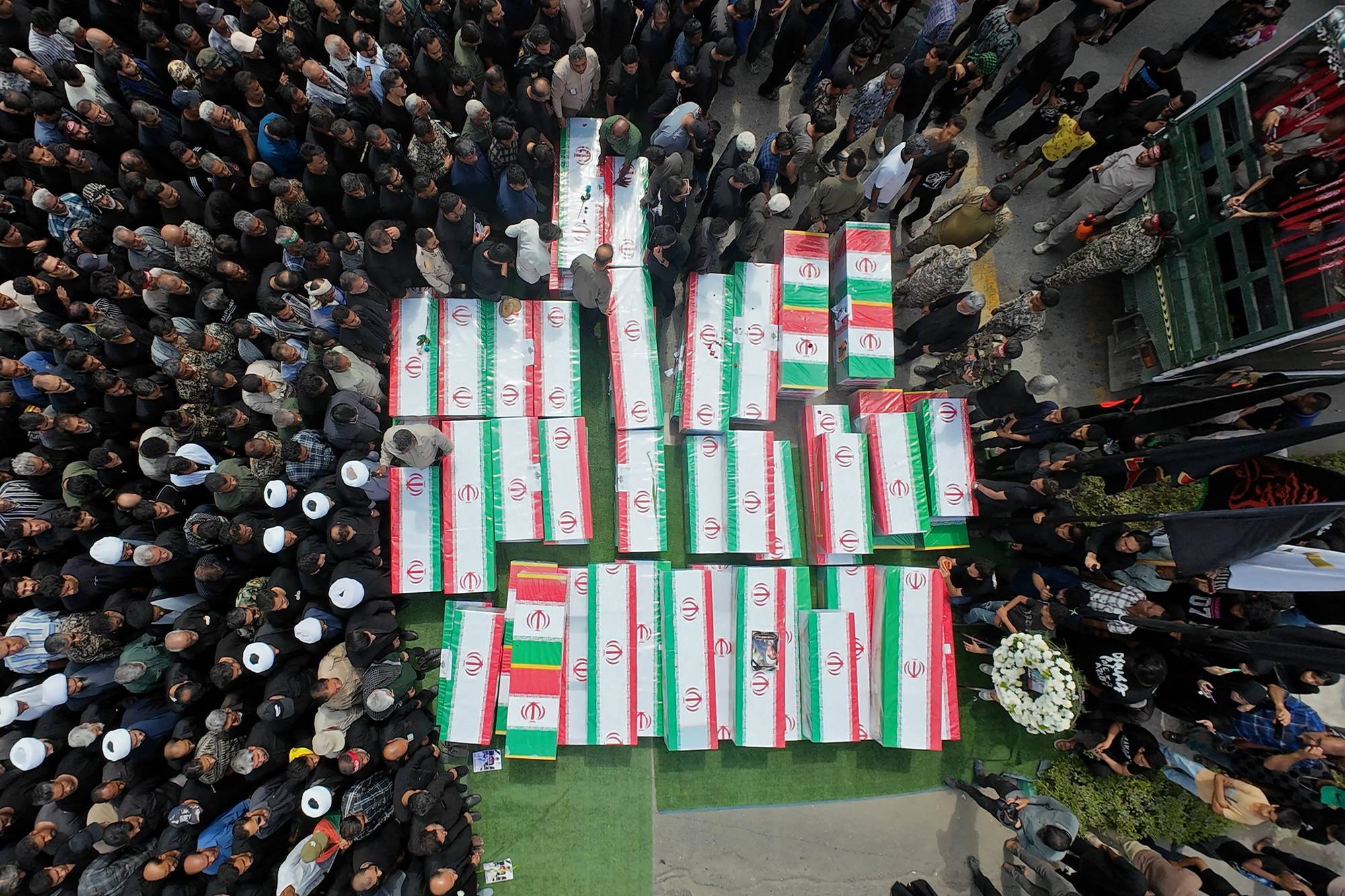 Coffins of victims of the US strike on a girls' school in Minab, Iran are surrounded by mourners