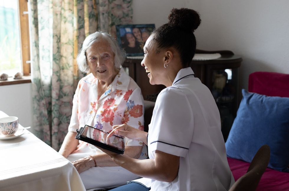 Community nurse and senior patient speak.