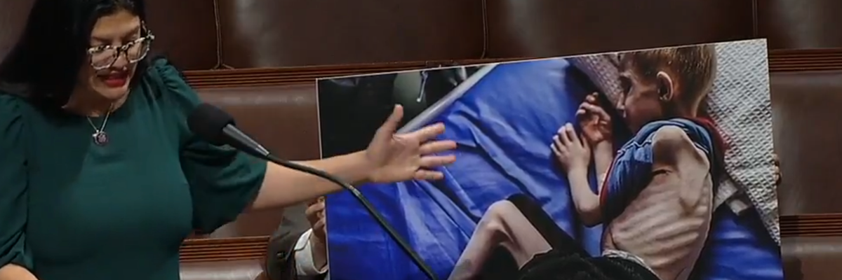 Congresswoman Rashida Tlaib speaks on the House floor pointing to a photo of a starving Gazan child