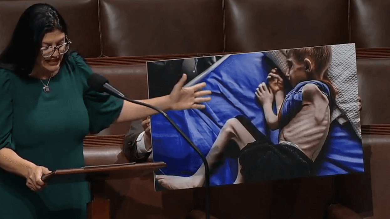 Congresswoman Rashida Tlaib speaks on the House floor pointing to a photo of a starving Gazan child