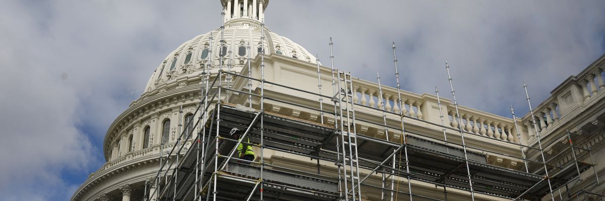 Construction workers walk on scaffolding at US Capitol