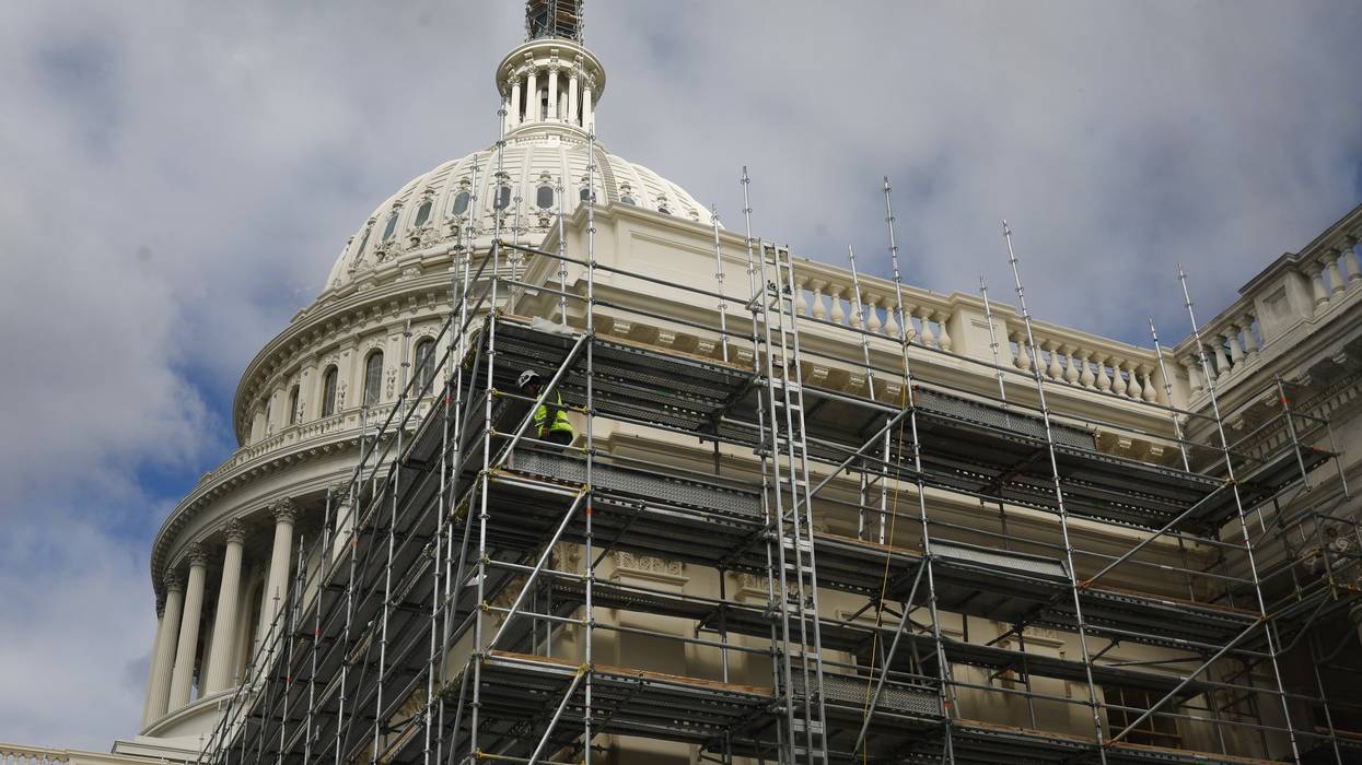 Construction workers walk on scaffolding at US Capitol