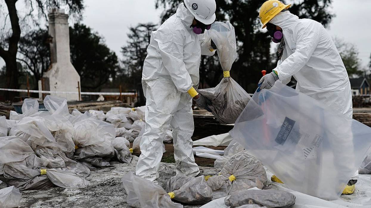 contractors in protective gear remove hazardous materials from a home destroyed in the Eaton Fire