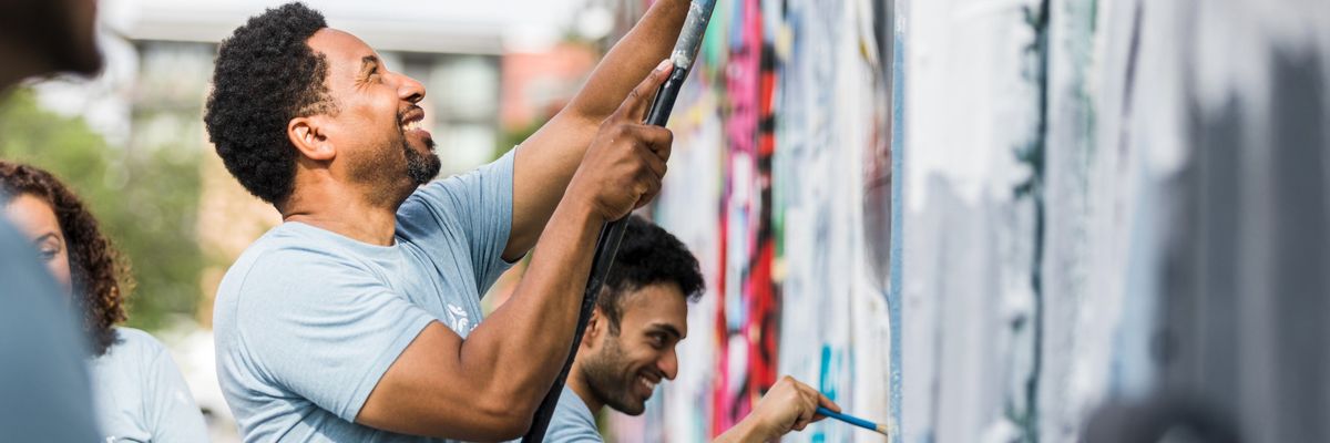 Coworkers smiling while they paint