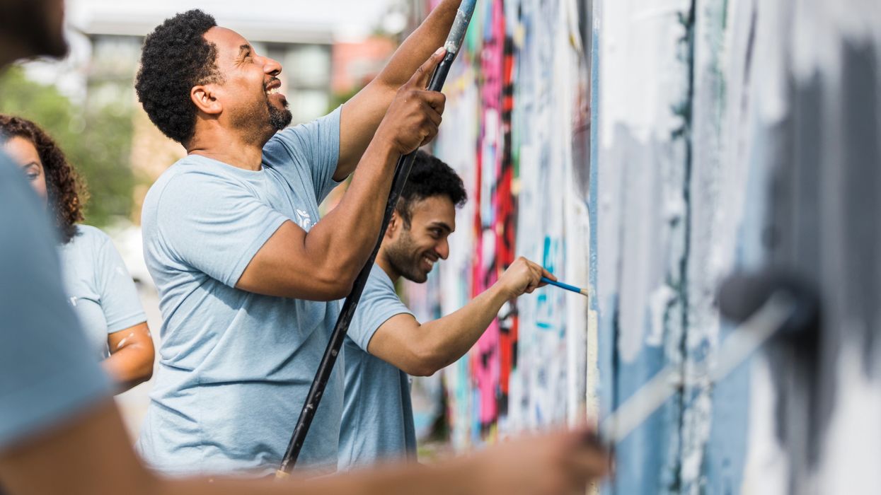 Coworkers smiling while they paint