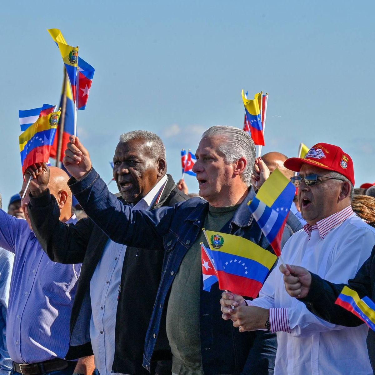 Cuban President Miguel Diaz-Canel flutters a Venezuelan national flag