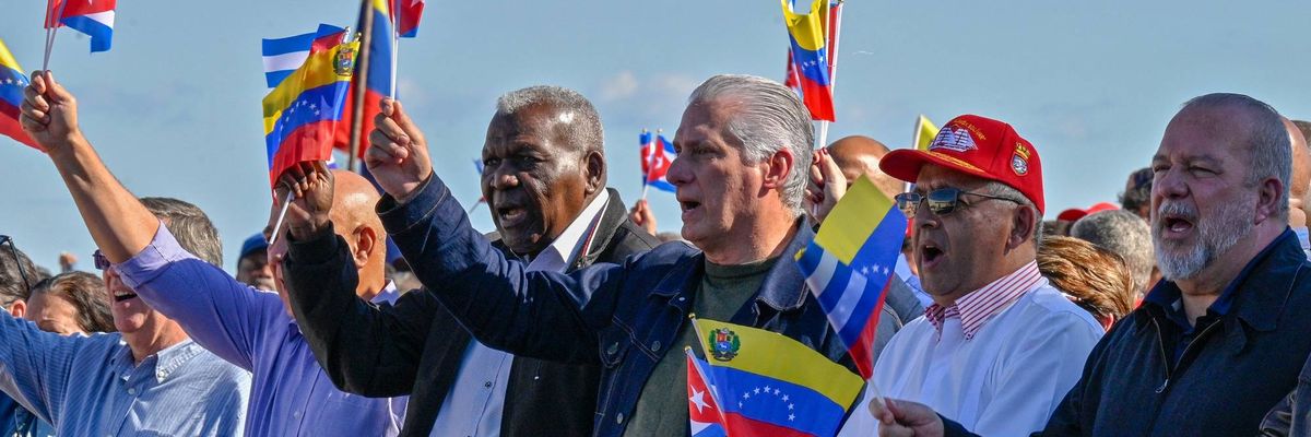 Cuban President Miguel Diaz-Canel flutters a Venezuelan national flag
