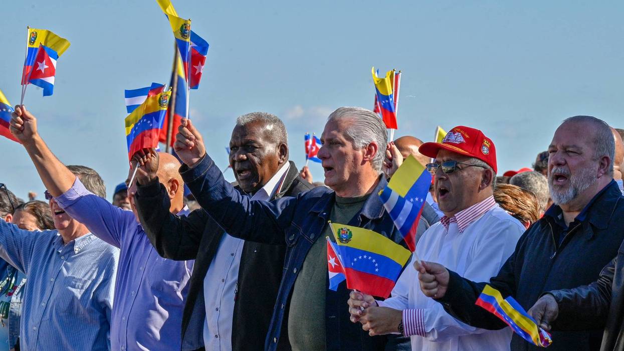 Cuban President Miguel Diaz-Canel flutters a Venezuelan national flag