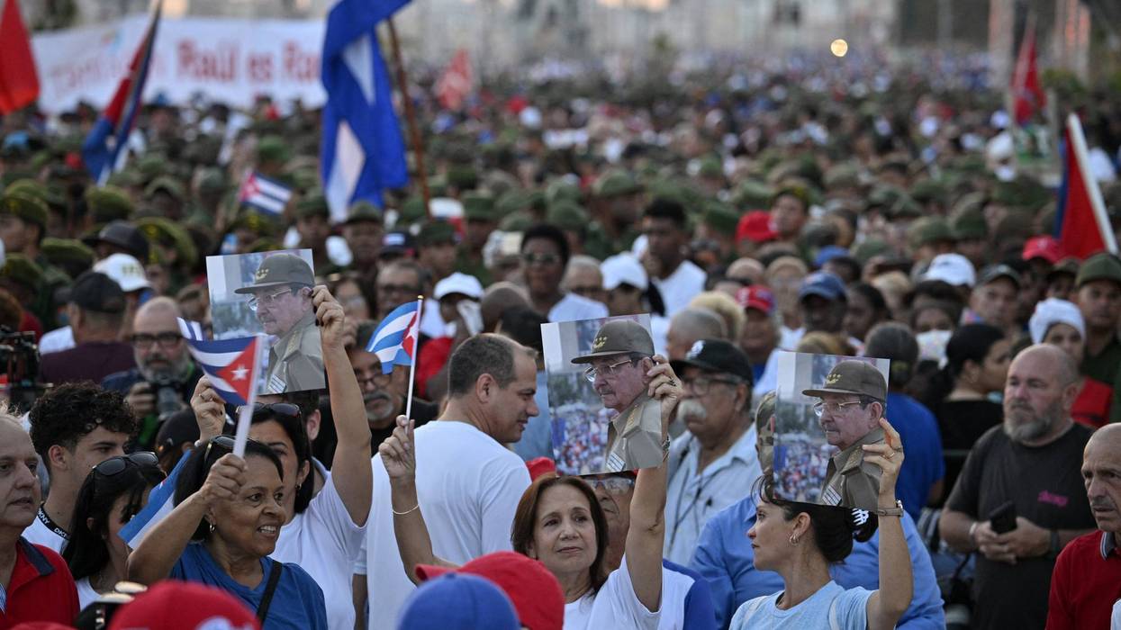 Cubans hold photos of Raúl Castro during a massive rally in Havana against US aggression