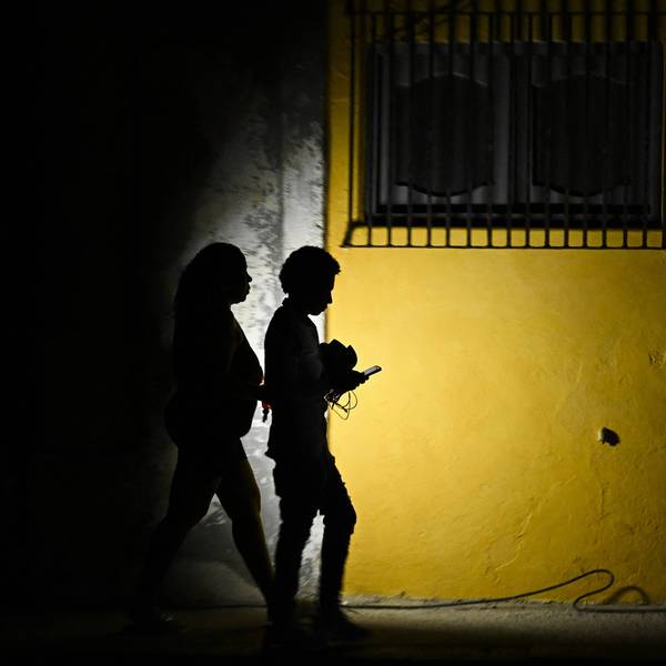 Cubans walk in the dark during a blackout