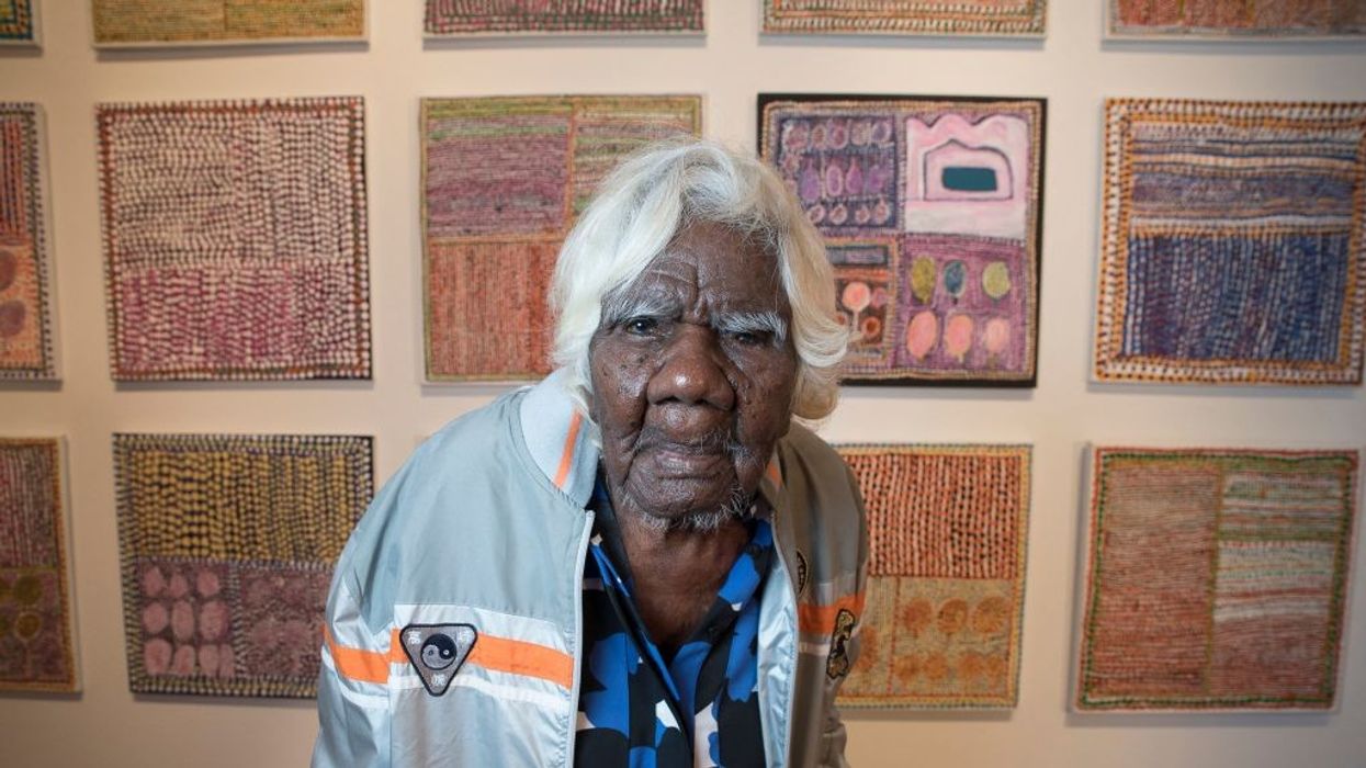 Daisy Loongkoonan stands in front of her paintings.