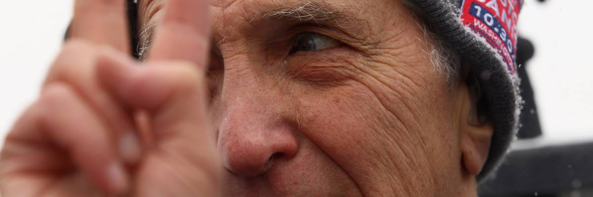 Daniel Ellsberg holds up a peace sign while demonstrating against the wars in Iraq and Afghanistan