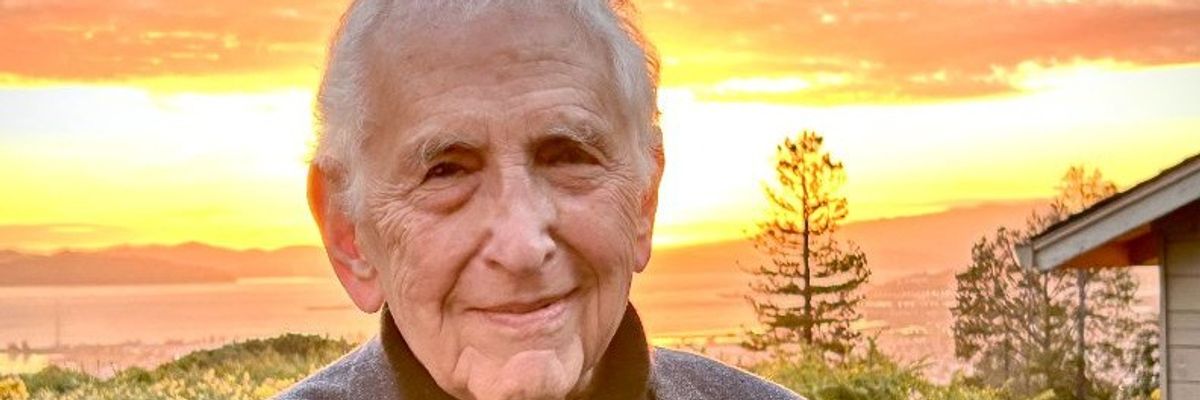 Daniel Ellsberg is pictured outside his home with the sun setting over the Pacific Ocean behind him.
