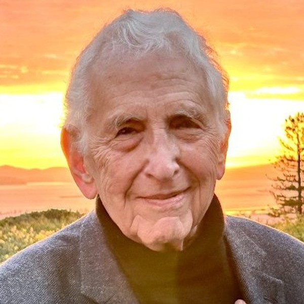 Daniel Ellsberg is pictured outside his home with the sun setting over the Pacific Ocean behind him.