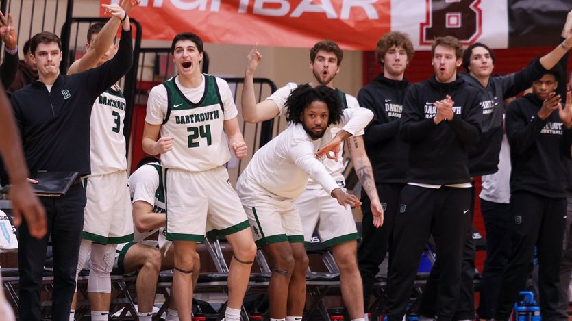 Dartmouth men's basketball players cheer on teammates from the sideline
