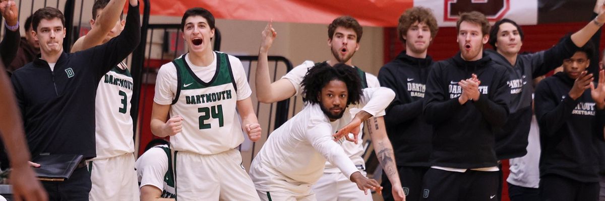 Dartmouth men's basketball players cheer on teammates from the sideline