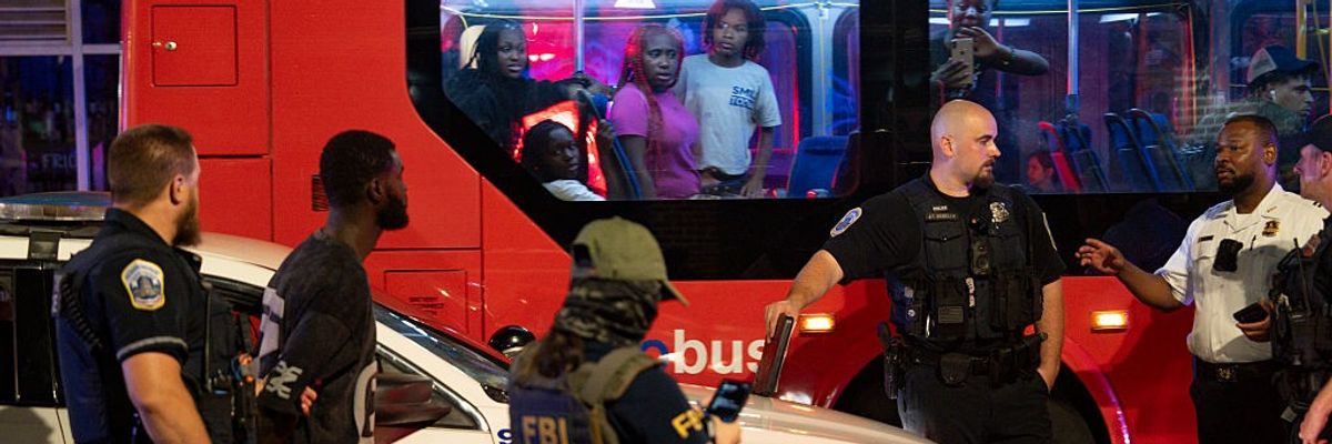 DC bus passengers watch federal and local officers take part in an arrest
