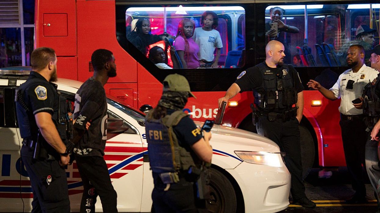 DC bus passengers watch federal and local officers take part in an arrest