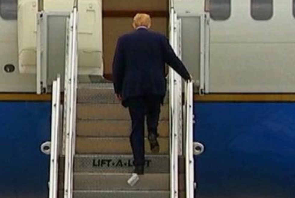 Defandant climbs airplane steps with toilet paper stuck to his foot.