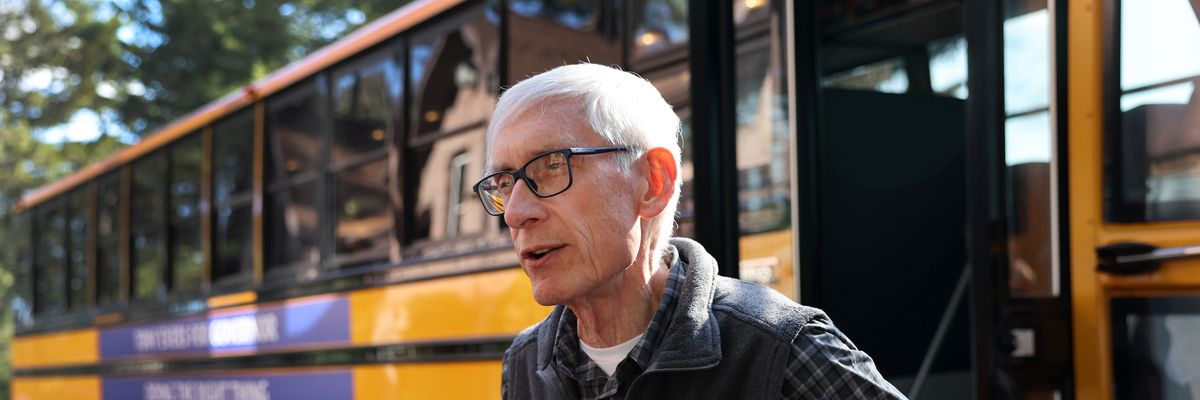 Democratic Wisconsin Governor Tony Evers speaks to the press next to the school bus he is using to tour the state following a campaign rally at the Sawmill Brewing Company in Merrill on November 3, 2022.