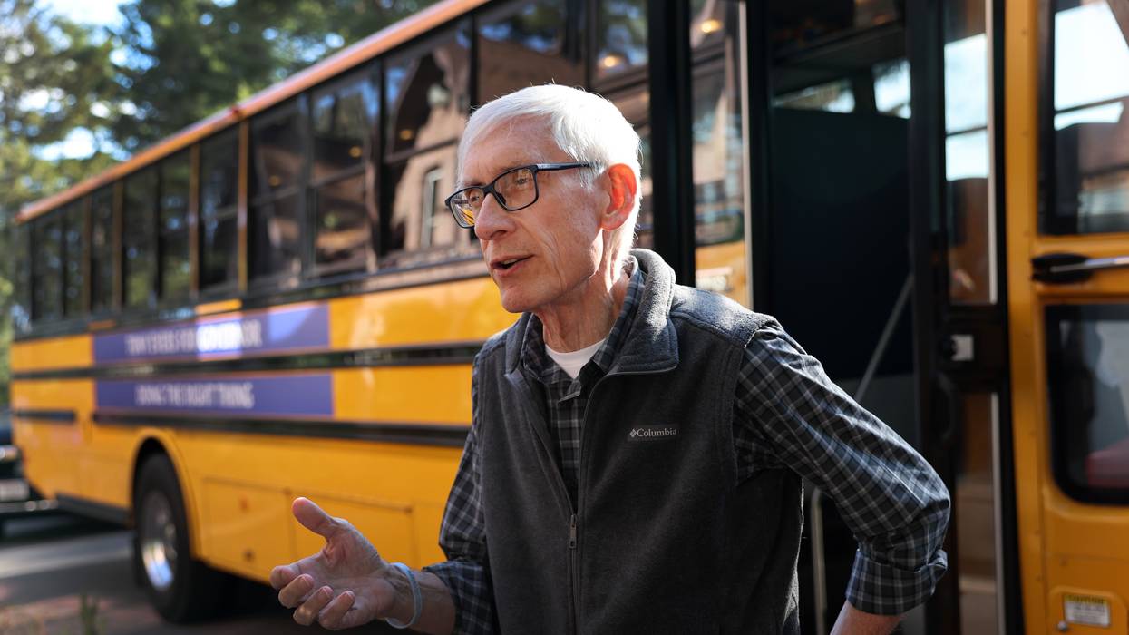 Democratic Wisconsin Governor Tony Evers speaks to the press next to the school bus he is using to tour the state following a campaign rally at the Sawmill Brewing Company in Merrill on November 3, 2022.