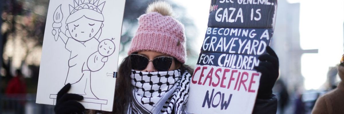 Demonstrator holding picture of Statue of Liberty and sign reading "Ceasefire Now"