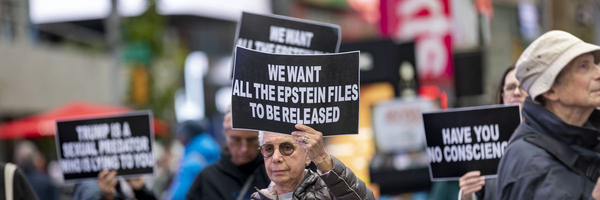 Demonstrators carry signs calling out Donald Trump's refusal to release files from the federal case against deceased sex offender Jeffrey Epstein