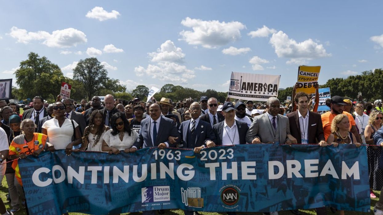 Demonstrators hold a banner reading, "1963-2023: Continuing the Dream."