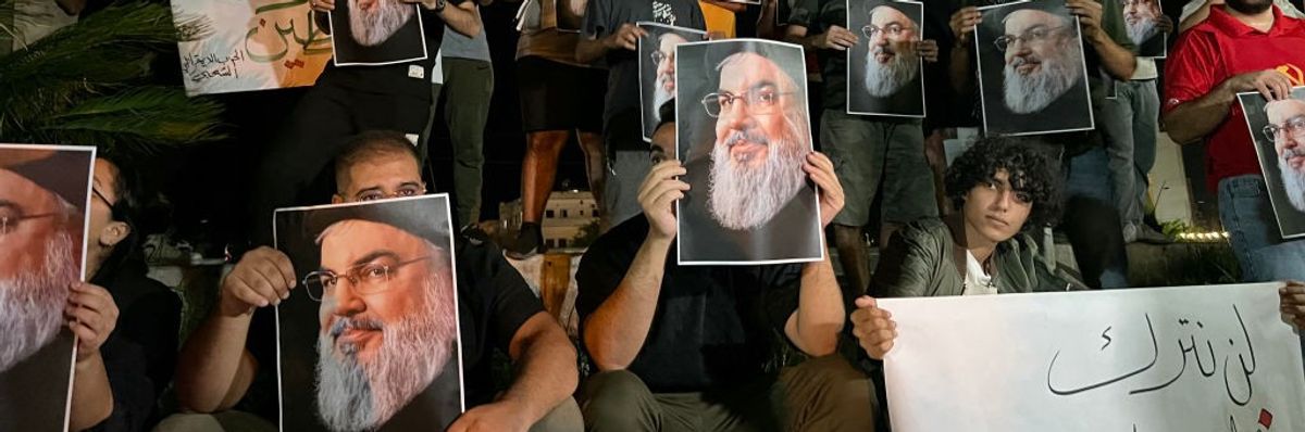 Demonstrators hold pictures of Hassan Nasrallah