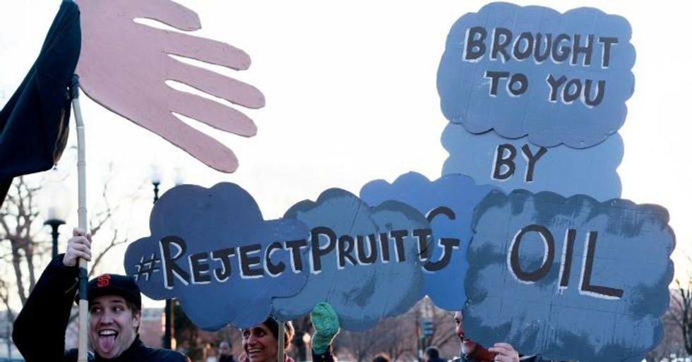 Demonstrators hold signs at a rally to stop the appointment of Scott Pruitt for the EPA. (Photo: Victoria Pickering/flickr/cc)